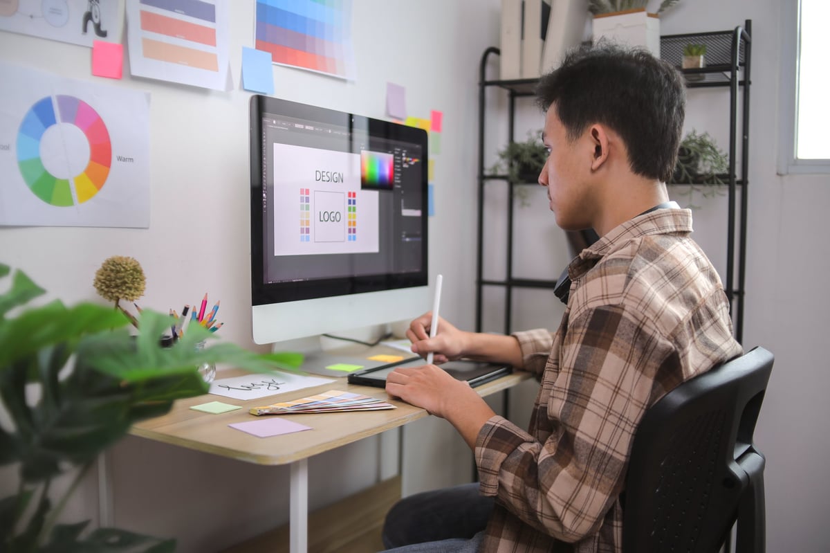 Young Designer Working on Logo with Sketch Pad on Office Desk